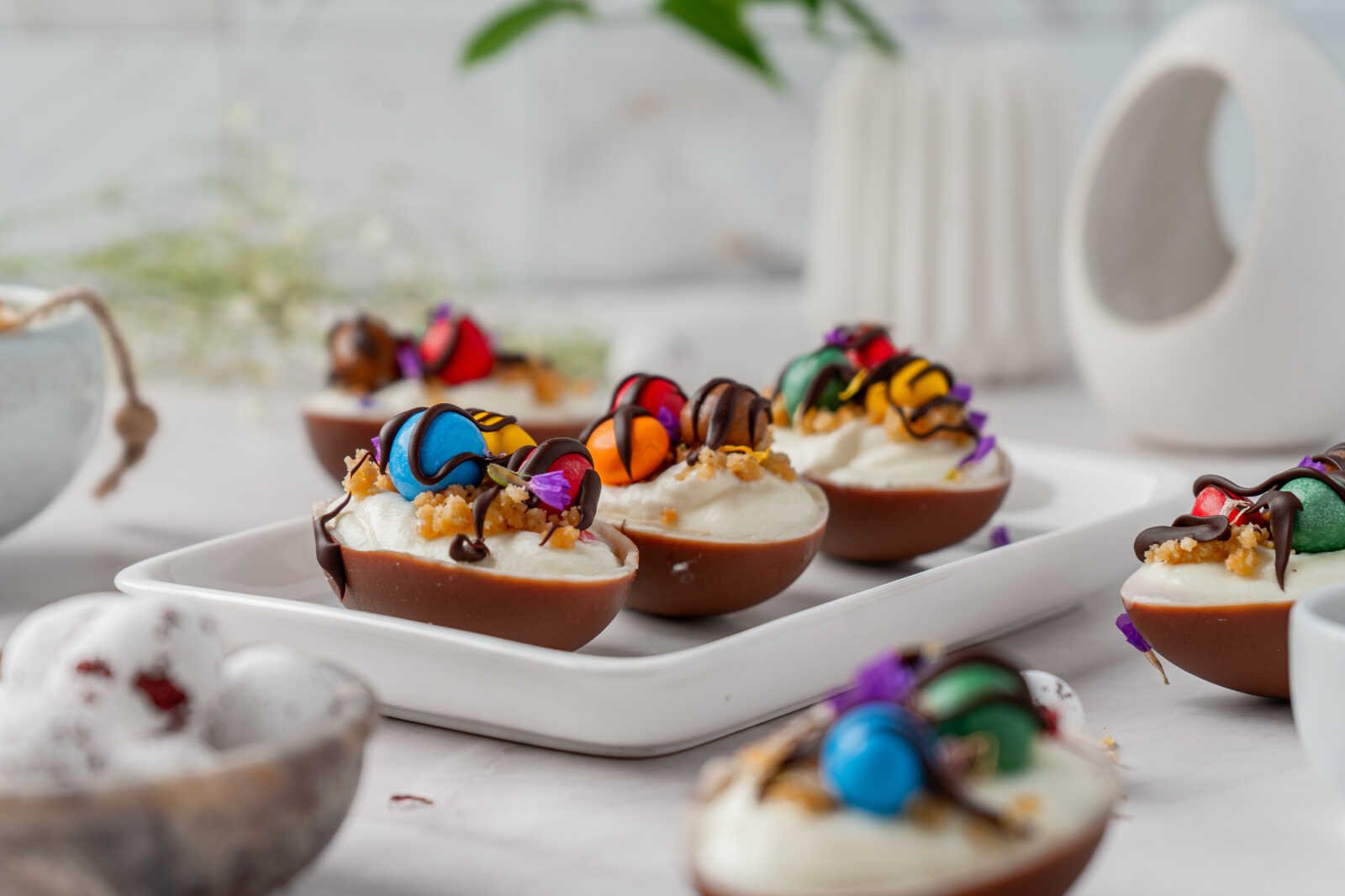 Tray of no bake Easter egg cheesecakes with colorful candy toppings