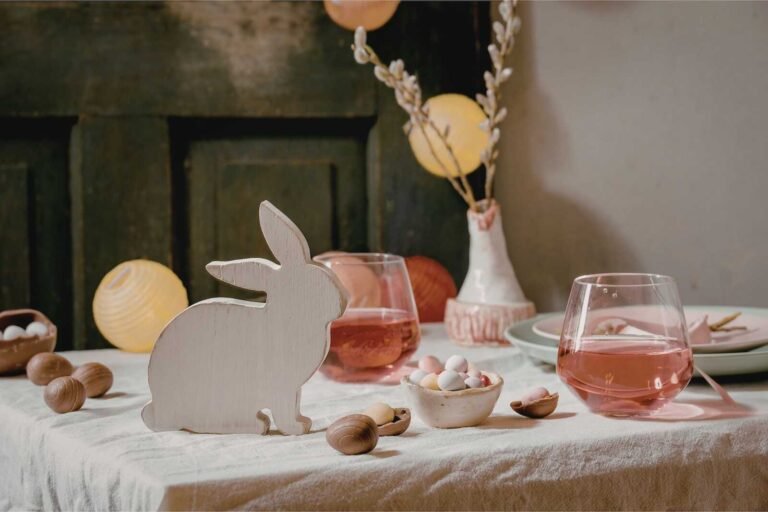 Easter table decor with wooden bunny, pastel candies, and spring decorations representing Easter traditions around the world.