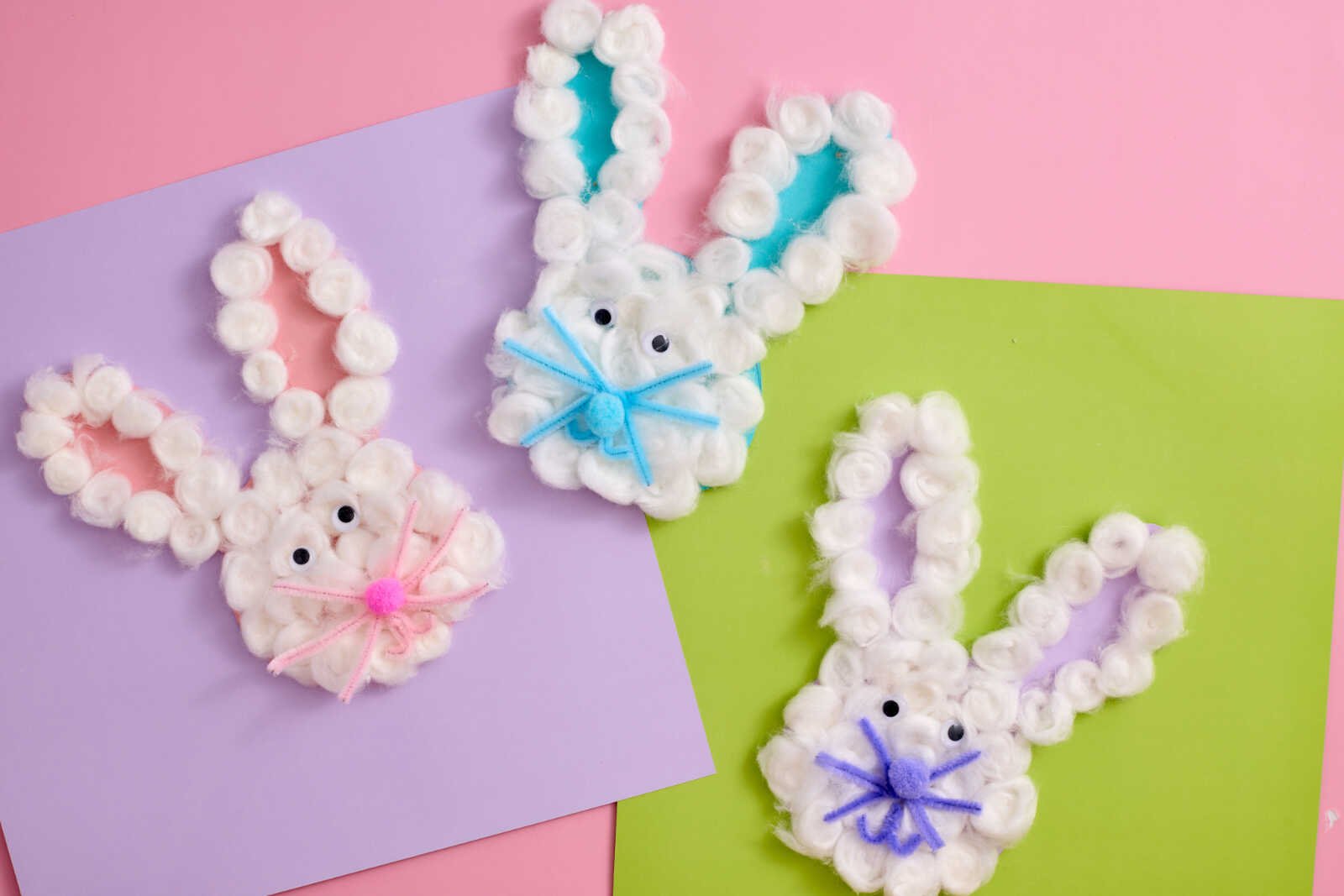 Bunny Cotton Craft trio with cotton balls, googly eyes, and colorful pipe cleaner whiskers on pastel cardstock.