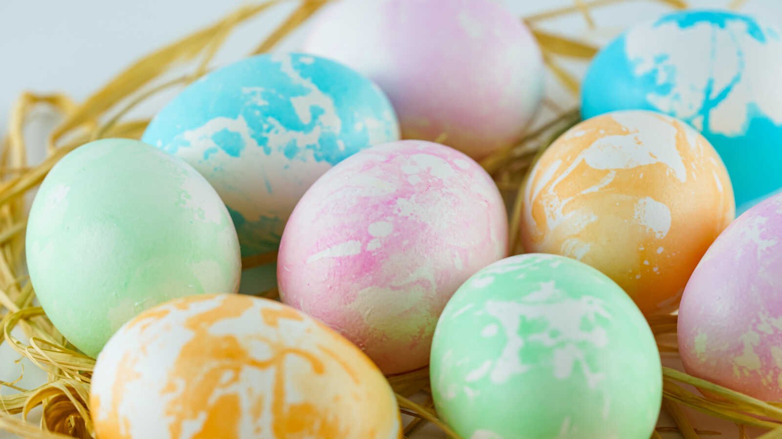 Colorful marbled Easter eggs in straw nest.